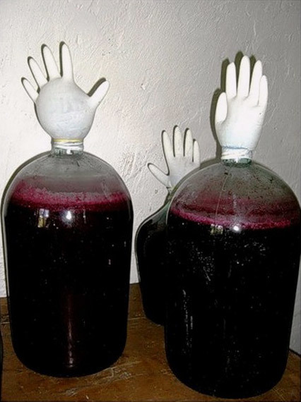 Домашнее вино с перчаткой на банке (бродильной емкости)